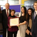 Jennifer Adams presenting Katie Fernandez Blake with her Teacher Award, accompanied by her students