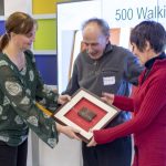 Jennifer Adams-Webb commemorates Leokadia and Elliott's entry into the "500 Tour Club" with a piece of World Trade Center steel.
